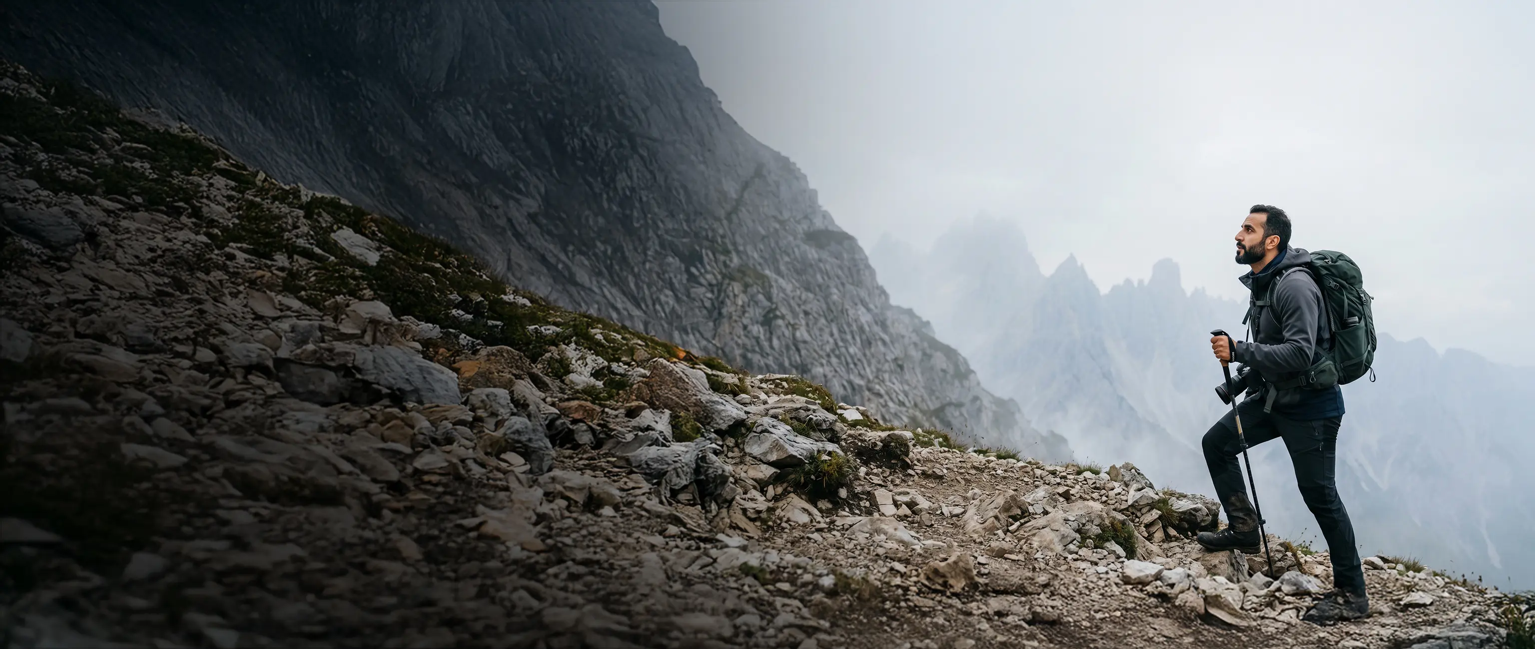 A mountain hiker looking towards the peak, symbolizing the journey and ambition to reach your financial goals with National Bonds.